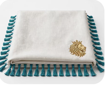 Royal Judah Ceremonial Altar Cloth — white bamboo-linen prayer shawl with deep teal hand-tied fringe tassels and gold embroidered Crowned Lion crest